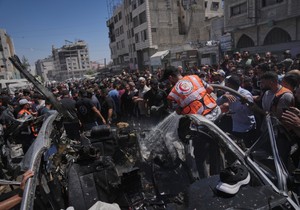 Palestinci oko automobila pogođenog u izraelskom napadu u gradu Gazi, 18. jun 2026.