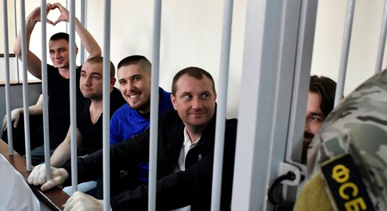 In the cramped courtroom, the sailors, who have described themselves as 'prisoners of war', were held in a metal-barred cage reserved for defendants