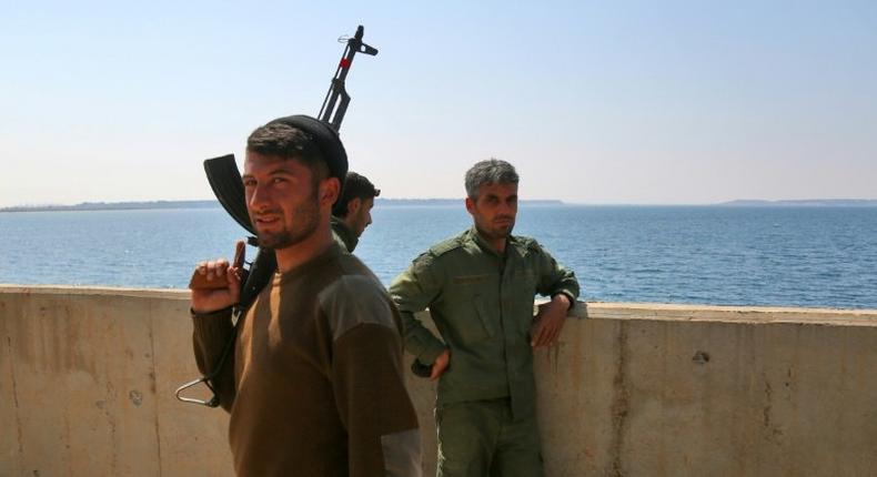 Fighters of the US-backed Syrian Democratic Forces guard a section of Tabqa Dam under their control on March 28, 2017