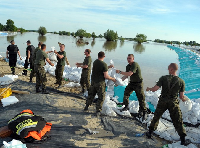 Żołnierze umacniają wał na Wiśle, chroniący przed zalaniem hutę szkła w Sandomierzu