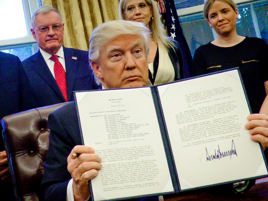 President Donald Trump signing an executive order in the Oval Office.