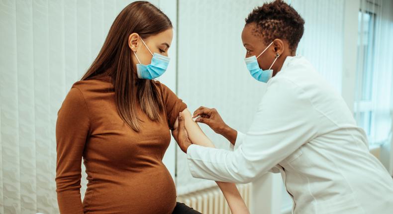A pregnant woman receives a vaccine.
