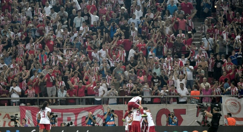 Olympiakos players and fans celebrate Mathieu Valbuena's equaliser against Tottenham