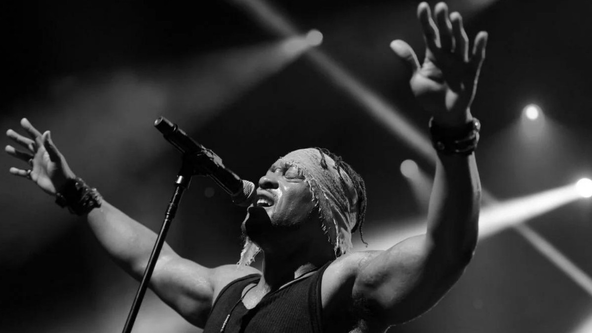 D'Angelo śpiewa na scenie z uniesionymi rękami