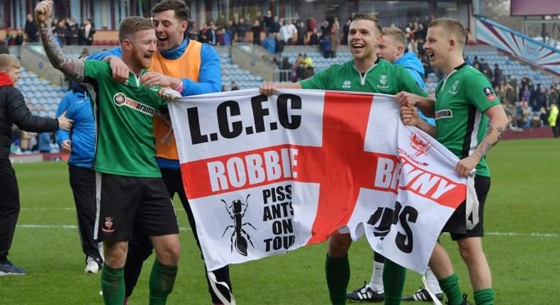 Lincoln City's midfielder Alan Power (L) and midfielder Terry Hawkridge (R) celebrate after winning the English FA Cup fifth round football match against Burnley February 18, 2017