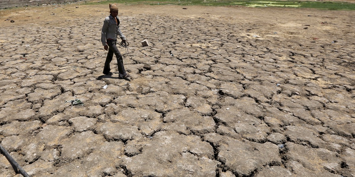 A man walks through a dried-up Sarkhej lake on a hot summer day in Ahmedabad in April 2016