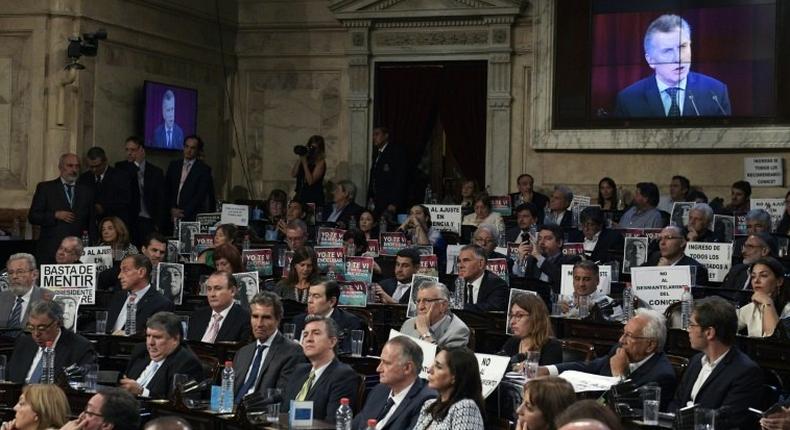 Opposition legislators hold banners as they listen to the speech of Argentina's President Mauricio Macri during the inauguration of the 135th period of ordinary sessions at the Congress in Buenos Aires on March 1, 2017