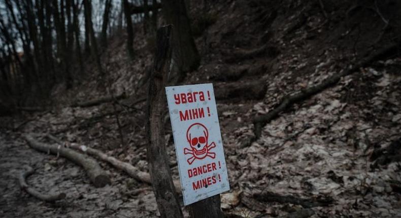 A billboard indicates the presence of landmines at the position of a Ukrainian volunteer unit in a suburb of Kyiv on February 28, 2023.YASUYOSHI CHIBA/AFP via Getty Images)