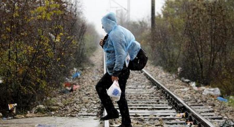 A Syrian refugee walks into Macedonia during a rainstorm after crossing the border from Greece to Macedonia near the Macedonian town of Gevgrelija November 27, 2015.