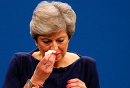 Britain's Prime Minister Theresa May wipes her nose after she suffered a coughing fit whilst addressing the Conservative Party conference in Manchester