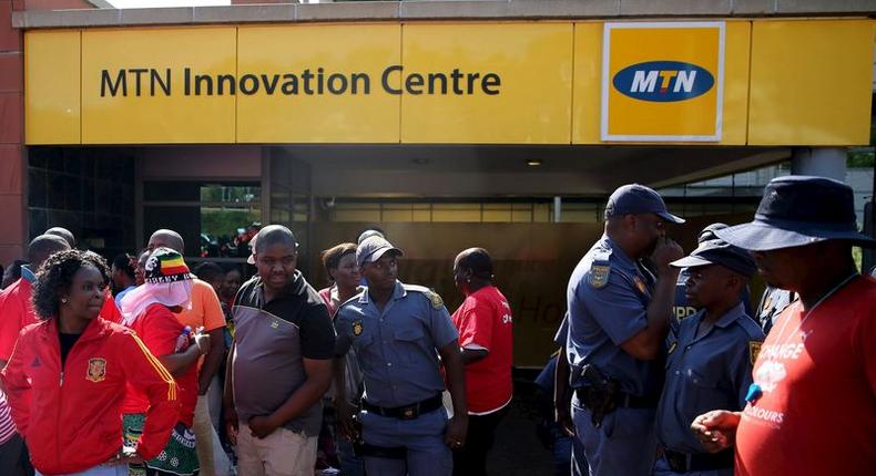 Police officers keep watch during a strike of MTN workers outside the company's headquarters in Johannesburg May 20, 2015. REUTERS/Siphiwe Sibeko