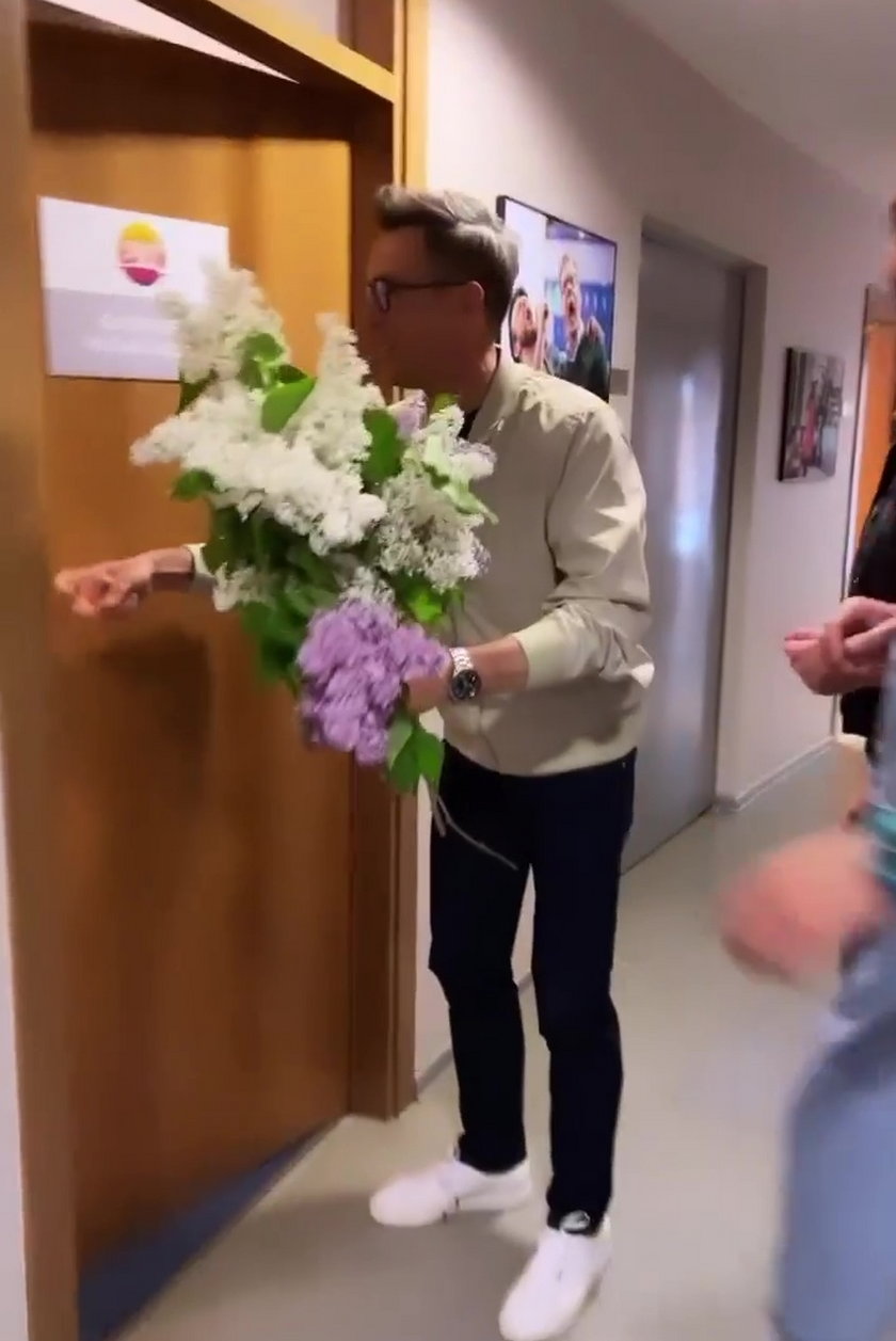 Maciej Kurzajewski wręczył koleżance z pracy bukiet kwiatów. 