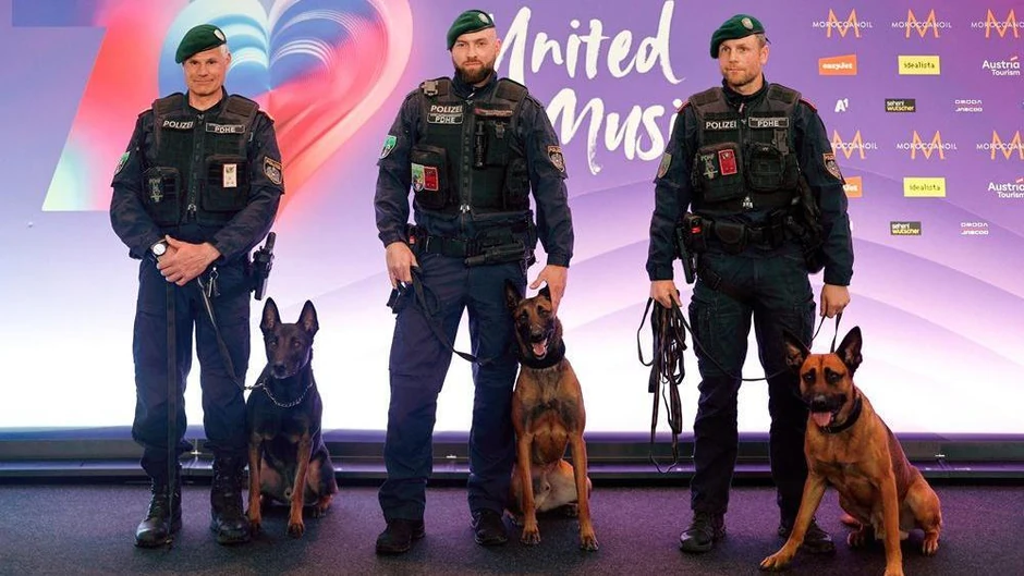 Austrijski policajci poziraju sa dresiranim psima ispred evrovizijskog panoa | Foto: REUTERS/Lisa Leutner