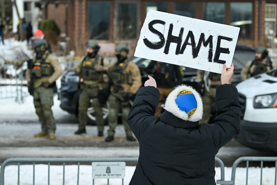 Žena drži natpis Stidite se dok policajci Mineapolisa reaguju na mesto gde je ženu ubio agent Službe za imigraciju i carine (ICE) u Mineapolisu, Minesota, SAD, 7. januara 2026. | Foto: CRAIG LASSIG/EPA/Shutterstock