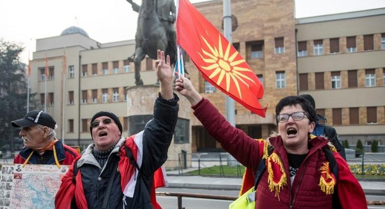 Demonstrators wave an old Macedonian flag during a protest against a process of renaming the country name in front of the Parliament building in Skopje on December 1, 2018, during the Parliament session