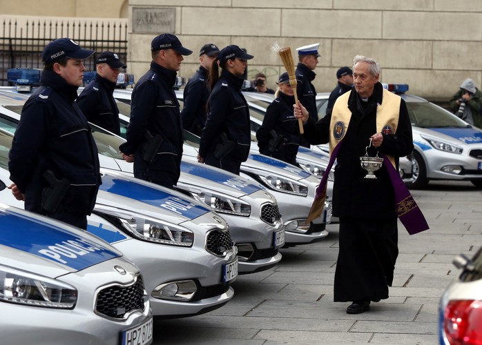 Kapelan KSP ks. Józef Jachimczak święci radiowozy przekazane warszawskim policjantom