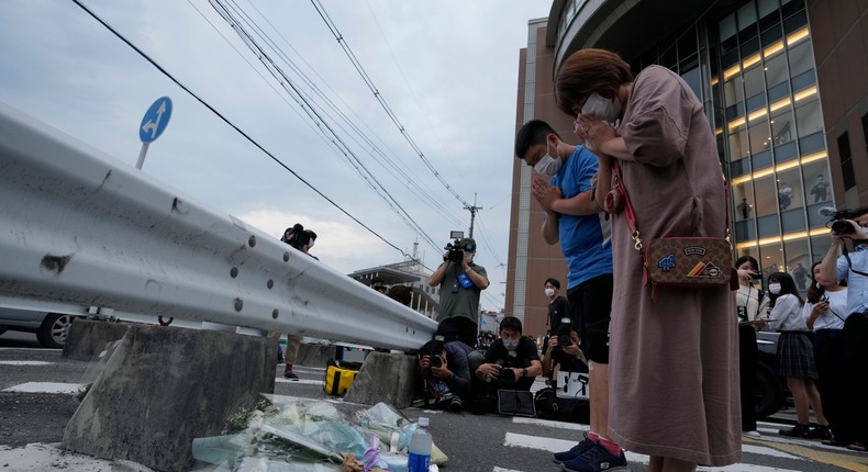 People visit a makeshift memorial at the scene where the former Prime Minister Shinzo Abe was shot while delivering his speech to support the Liberal Democratic Party's candidate during an election campaign in Nara, Friday, July 8, 2022.