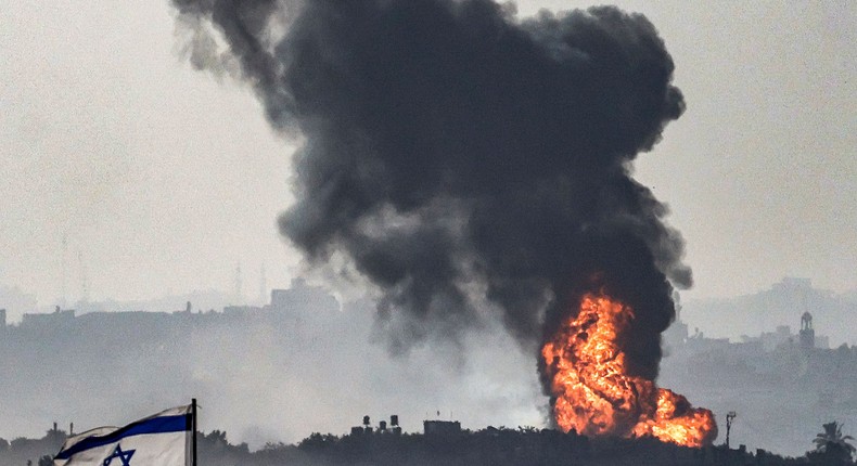 An Israeli flag flies in southern Israel as a fireball erupts across the border in the Gaza Strip.RONALDO SCHEMIDT/AFP via Getty Images