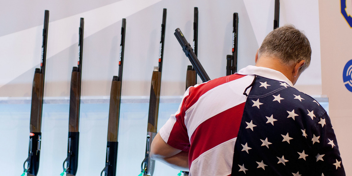 A man looks at a shotgun display at the NRA Annual Meetings and Exhibits.