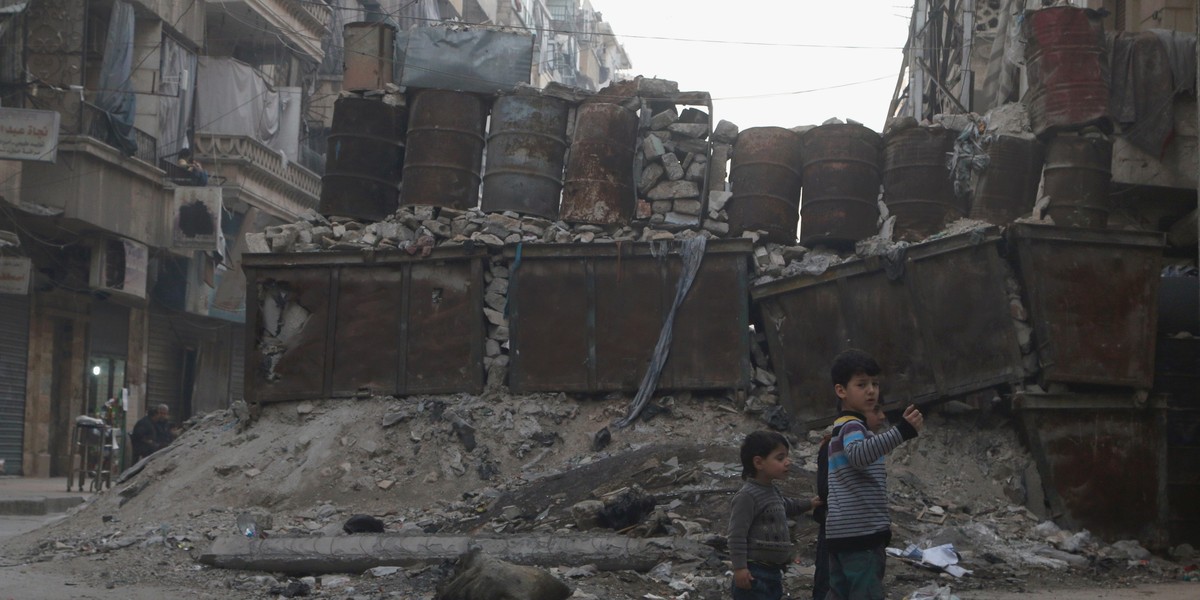 Children play near barricades in a street, which serve as protection from snipers loyal to Syria's President Bashar al-Assad, in Aleppo's rebel-controlled Bustan al-Qasr neighbourhood, Syria April 6, 2016