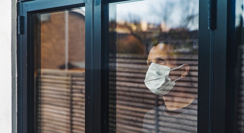 A man in self-isolation looks out the window.