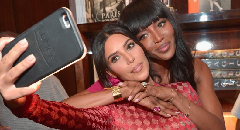 Kim Kardashian, left, snaps a selfie with Naomi Campbell using a LuMee case.