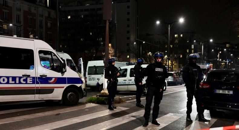 French police officers stand guard at the site where a robber armed with a handgun held several people in a travel agency on the Massena Boulevard, in the Porte d'Italie area in Paris, on December 2, 2016