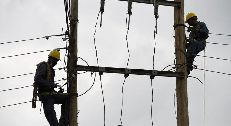 [FILE] Kenya Power and Lighting Company (KPLC) live line experts dismantle power cables to relocate power lines to pave way for the construction of the Nairobi Expressway in Westlands, Nairobi, on September 24, 2020. (Photo by SIMON MAINA/AFP via Getty Images)