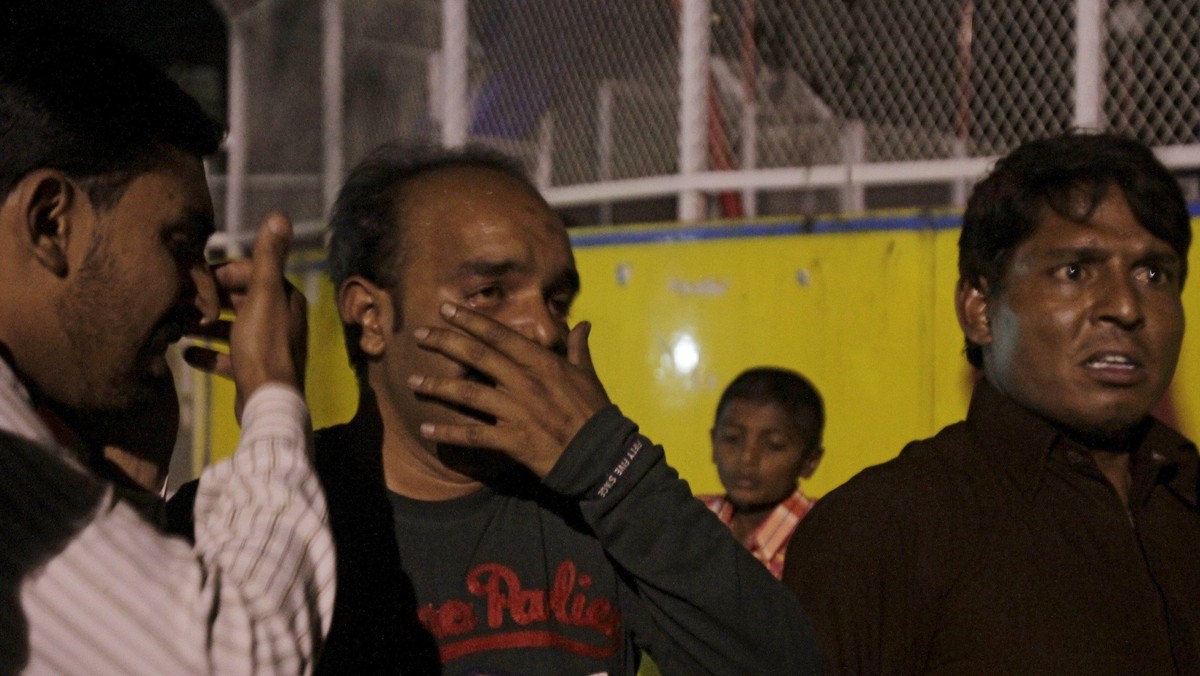 Men mourn the death of their relatives after a blast outside a public park in Lahore, Pakistan