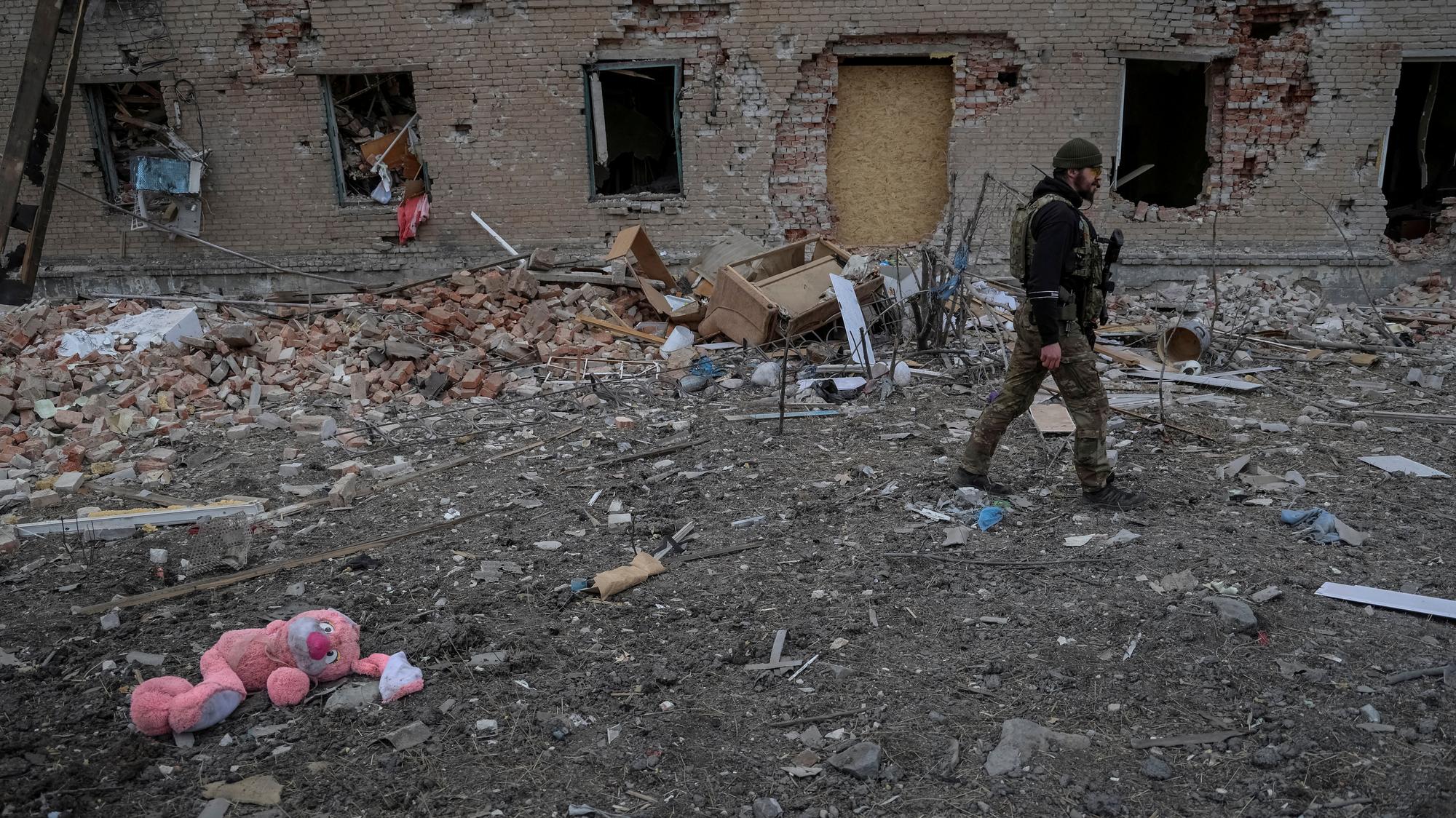 Ukrajinský vojak neďaleko zničenej budovy uprostred ruského útoku na Ukrajinu v meste Časiv Jar, 5. marca 2024.