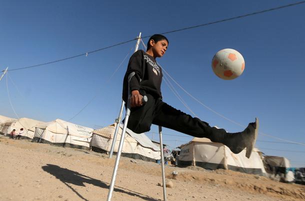 Niepełnosprawny trzynastolatek z Iraku gra w piłkę nożną.