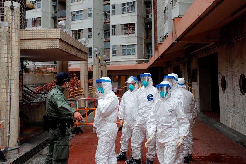 Police in protective gear wait to evacuate residents from a public housing building, following the o