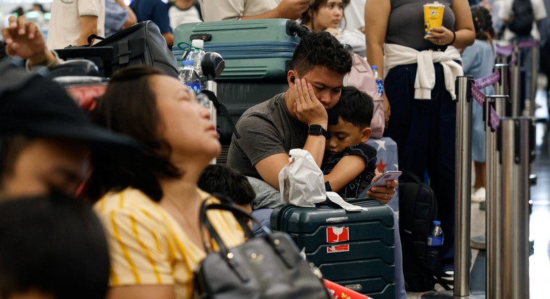 Hong Kong Express Airways passengers queue at counters in Hong Kong International Airport amid system outages disrupting the airline's operationsTyrone Siu/Reuters