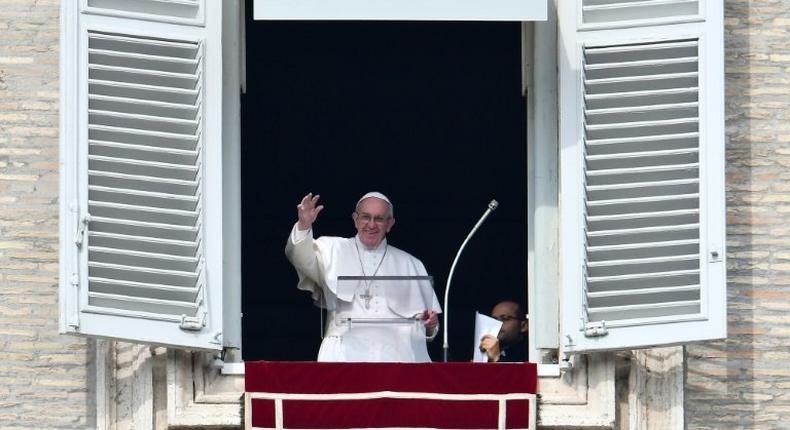 Pope Francis waves to pilgrims gathered in St. Peter's square during his Sunday Angelus prayer on February 12, 2017 at the Vatican