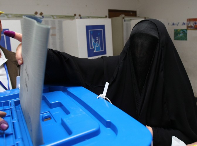 Kobieta wrzuca swój głos do urny w Bagdadzie podczas wyborów do irackiego parlamentu 7 marca 2010