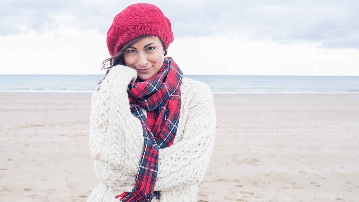 Cute smiling young woman in stylish warm clothing