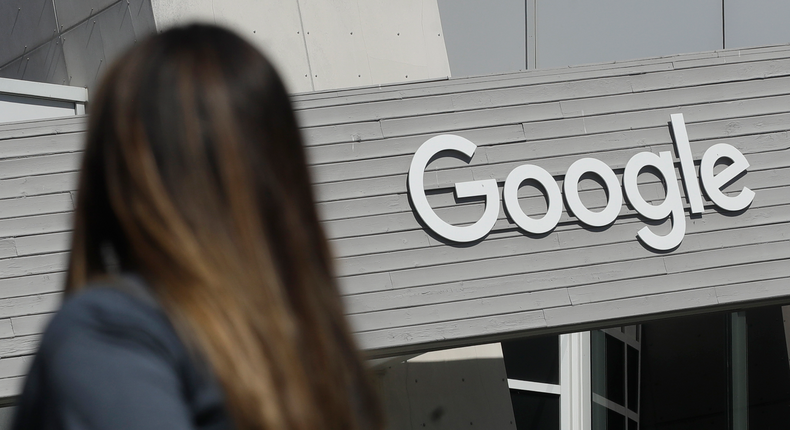 FILE - In this Sept. 24, 2019, file photo a woman walks below a Google sign on the campus in Mountain View, Calif. Alphabet Inc., parent company of Google reports financial earns on Monday, Oct. 28. (AP Photo/Jeff Chiu, File)