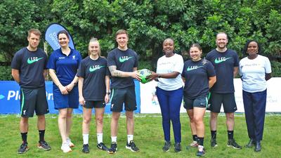 Standard Chartered's Joyce Kibe (centre white shirt) welcomes LFC Coaches to Kenya