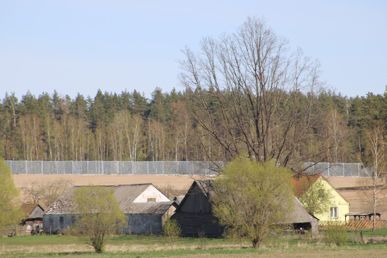 Metalowa zapora na granicy polsko-białoruskiej widziana od strony wsi Jałówka