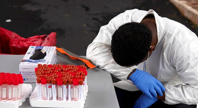 An illustrative photo of a health worker with Coronavirus test kits. [Business Insider] 