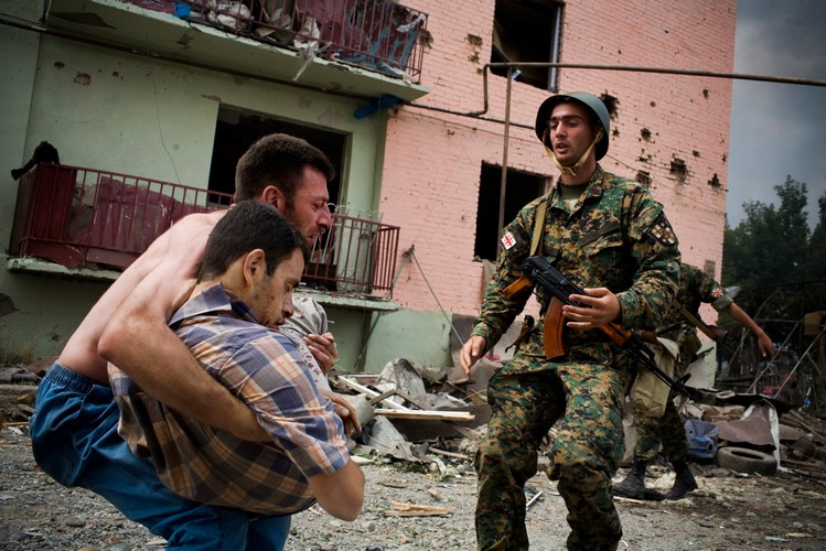 Mężczyzna niesie krewnego po rosyjskim ataku na trzy cywilne budynki w Gori, 9 sierpnia 2008
