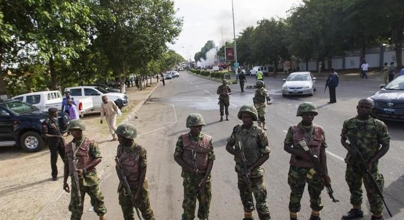 Nigerian army soldiers stand guard as they cordon off a road leading to the scene of a blast at a business district in Abuja June 25, 2014. REUTERS/Afolabi Sotunde