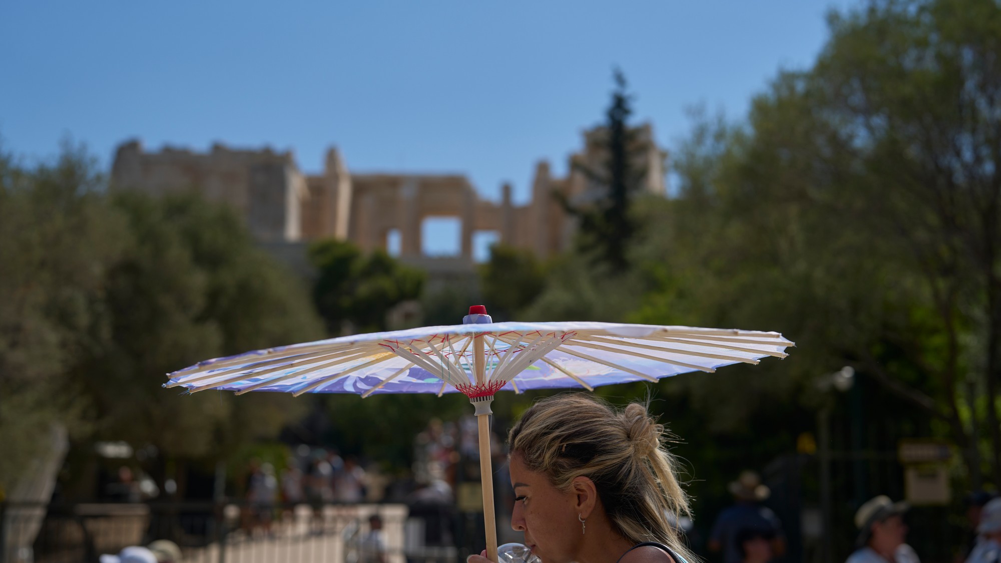 Na snímke turistka kráča s dáždnikom počas vlny horúčav pred aténskou Akropolou.