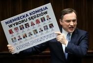 Rozemocjonowany Zbigniew Ziobro pokazuje planszę podczas wystąpienia w Sejmie