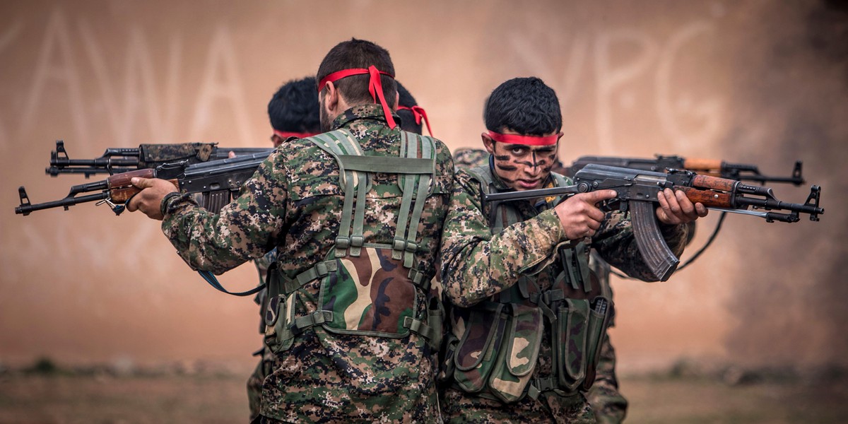 Fighters of the Kurdish People's Protection Units (YPG) carry their weapons at a military training camp in Ras al-Ain, February 13, 2015.