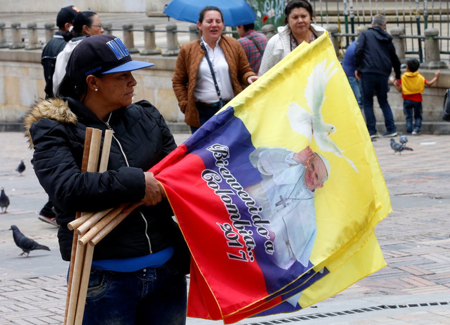 A woman sells Colombian flags with the image of Pope Francis outside the Cathedral of Bogota, September 2, 2017.