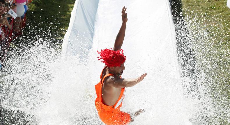 A participant lands in the water as he fails to cross a pool of water and foam on an inflated item.