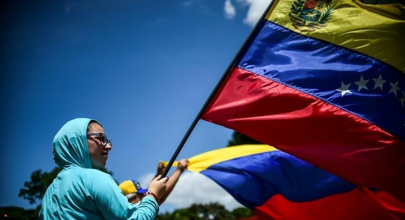 An anti-government activist demonstrates against Venezuelan President Nicolas Maduro at a barricade set up on a road in Caracas on August 8, 2017