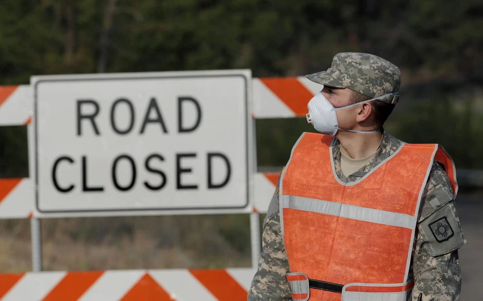Pripadnik Nacionalne garde Novog Meksika nosi masku na putu kod Los Alamosa, zatvorenog zbog požara