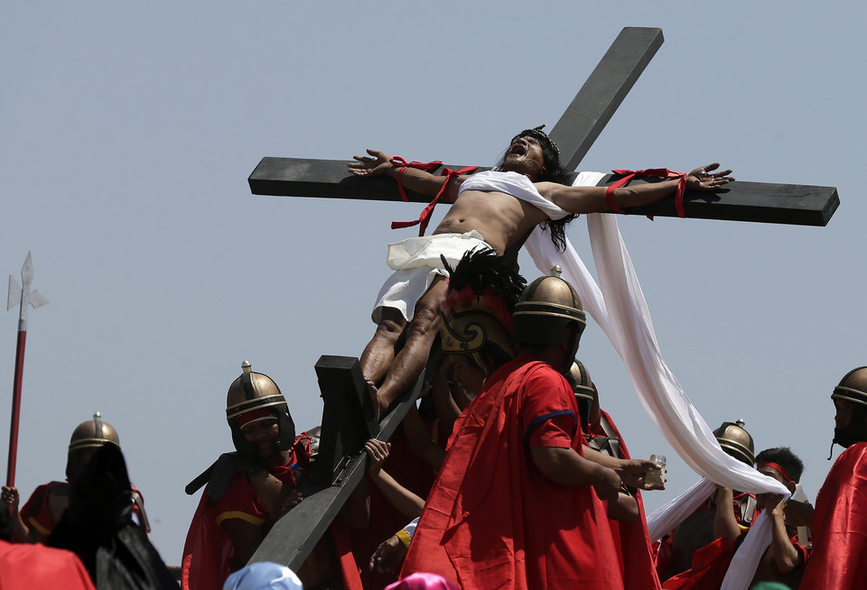 PHILIPPINES HOLY WEEK (Penitent is nailed to a wooden cross during the re-enactment of the crucifixion of Jesus Christ on Good Friday)